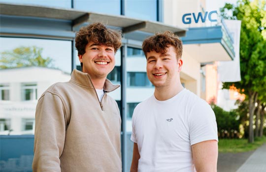 Zwei junge Personen vor dem Eingang der GWC